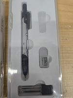 Close view of deformable compass, sharpener, and leads inside case