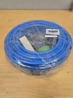 Coiled blue tubing in shrink wrap on table