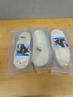 Three sealed rainproof shoe covers on tabletop