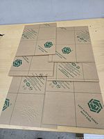 Six acrylic sheets with brown protective paper on tabletop