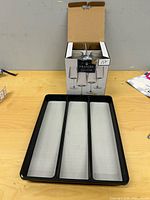 Boxed wine glasses and utensil tray on table