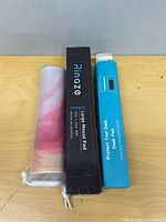 Three desk mats: Rinaze boxed, blue-boxed pad, pink marble pad in pouch