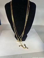 All three necklaces displayed with assorted pendants visible on black bust