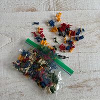 Bag of multicolor miniature plastic figurines with several loose pieces displayed