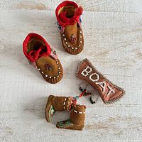 Full lot showing moccasins, miniature boots, and boat ornament
