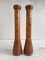 Front view of both wooden bobbin candlesticks standing upright