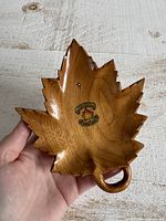 Front view of carved wooden maple leaf bowl with decal