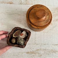 Overview of both wooden dishes, one lidded, with stone specimens inside carved dish