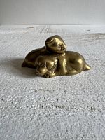 Front view of brass figurine showing two puppies
