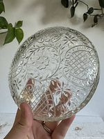 Top view of clear pressed glass lidded dish showing floral, lattice and scroll patterns
