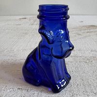 Front left view of cobalt blue glass dog dispenser