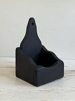 Front angled view of black wooden wall pocket shelf