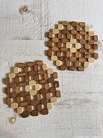 two circular wood bead trivets on light wood surface