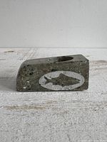 Side view showing fish motif on stone tealight holder