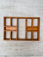 Front view of wooden display shelf showing cubby layout