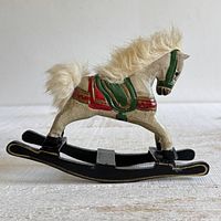 Left profile of wooden rocking horse on black rockers