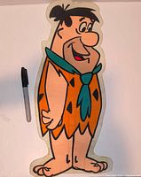 Full view of Fred Flintstone felt hanger with marker for scale