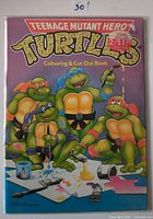 Front cover of Teenage Mutant Hero Turtles Colouring & Cut Out Book showing turtles painting and price sticker