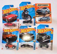 Front view of all seven sealed die-cast vehicles on their cards