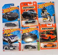Front view of six sealed Hot Wheels and Matchbox vehicles on cards