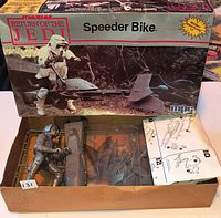 Box front, opened tray showing partially assembled speeder bike pieces, rider figure, instruction sheet