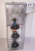 Side view of sealed blister pack showing three stacked HeroClix figures on dial bases