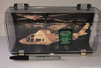 Helicopter inside clear plastic case with camouflage finish visible