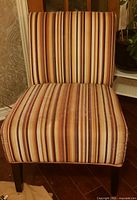 Front view of striped armless lounge chair showing upholstery and wear