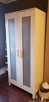 Front view of white two-door IKEA wardrobe with ribbed plastic panels