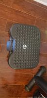 Top view of black ergonomic foot rest showing textured surface and logo