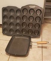 Two 12-cup muffin tins and non-stick griddle pan with folding wooden handle