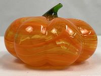 Side view of orange swirl glass pumpkin showing lobes and glossy finish