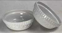 Two matching white textured ceramic bowls side by side