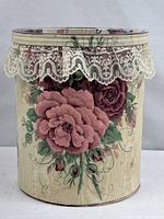 Front view of floral fabric-covered wastebasket showing rose pattern and lace trim