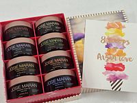 Gift box opened showing eight body butter jars and insert card