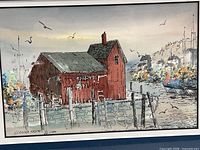 Close view of artwork showing red barn, waterfront scene, signature area visible
