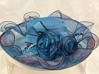Top view of teal organza hat showing ribbon rosettes and loops