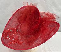 Full view of red wide-brim hat showing net bow and rhinestone appliqués