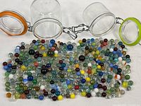 Two open clamp-lid jars and large spread of marbles