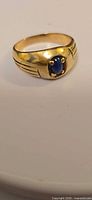Ring front view showing blue cabochon and gold setting