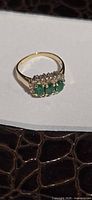 Full view of 14K yellow gold ring with three emeralds