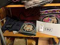 Shelf with embroidered bags, boxed items, folded clothing