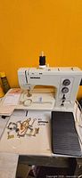 Bernina sewing machine with foot pedal, manual, presser feet visible