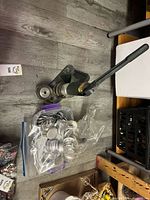 Button press with dies and bags of button parts on floor