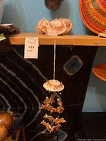 One assembled ceramic wind chime hanging; shows domed top, beads and rabbit figures.