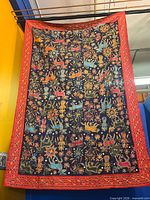 Full view of hanging tapestry showing overall design and red border