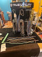 Overall lot on display rack with many beaded strands and necklaces