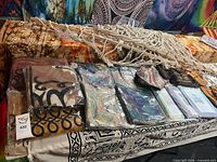 Lot overview showing hammock, packaged tapestries, bandanas, coconut purses, sandals