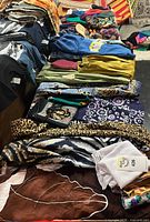 Table view showing folded pants, scarves, pouch and T-shirt