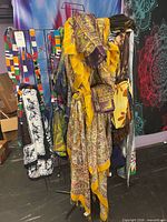 Rack holding yellow-border paisley scarves and assorted patterned fabrics